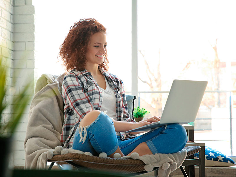 Mulher pesquisando no notebook cirurgias plásticas que deram errado no Brasil