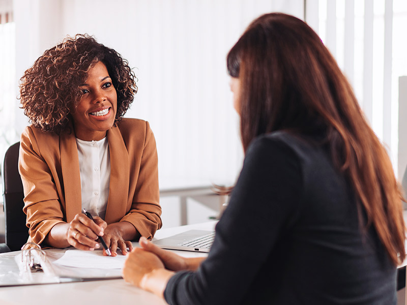 Mulher conversando com gerente sobre financiamento no banco para silicone nas mama 