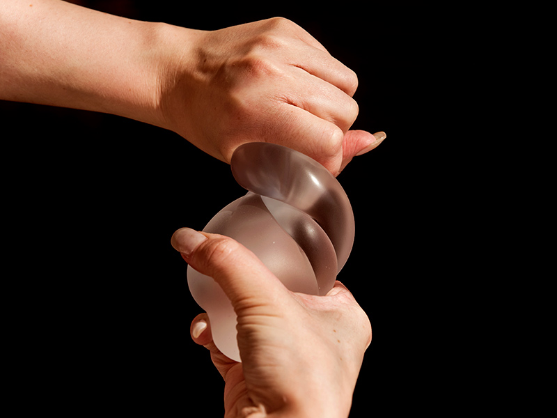 Mãos torcendo uma prótese de silicone