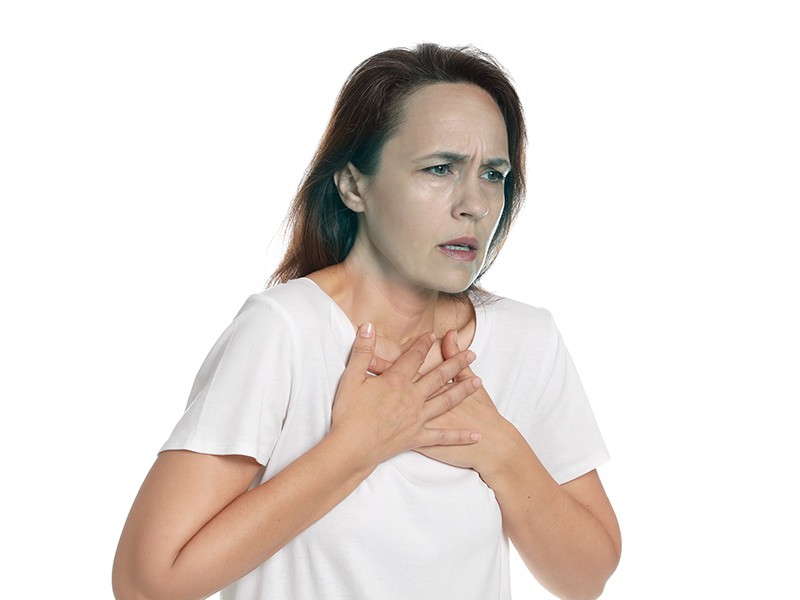 Mulher com embolia pulmonar maciça com a mão no peito, e o rosto com cianose