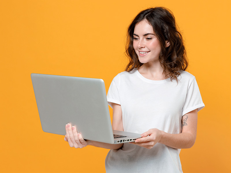 Mulher de camiseta branca segurando um notebook, pesquisando sobre seroma na lipoaspiração 