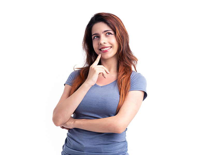 Mulher de camiseta azul sorrindo com a mão no queixo, pensando nos remédios caseiros para trombose venosa profunda