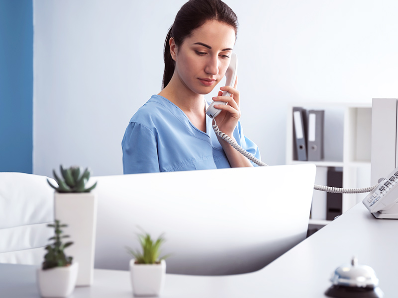 Imagem de uma enfermeira prestando atendimento telefônico às pacientes em pós-operatório