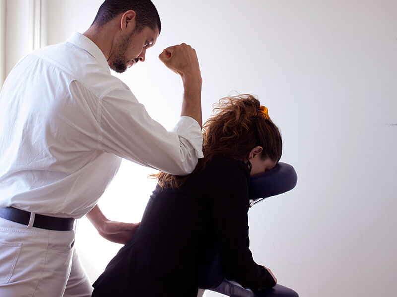 Imagem de um esteticista realizando uma quick massage na paciente