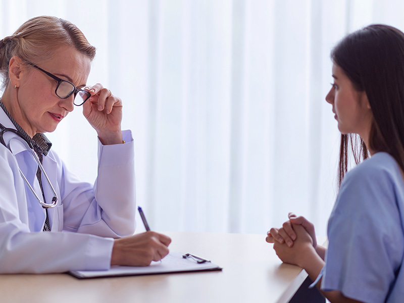 Imagem de uma médica e sua paciente conversando sobre quanto custa o retoque da lipoaspiração