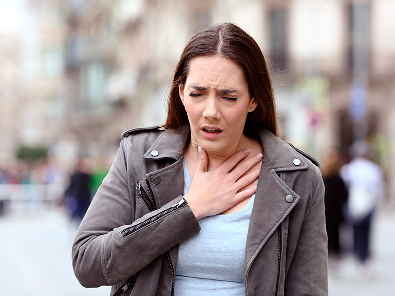 Na imagem uma mulher aparece com sintomas de problemas respiratórios 