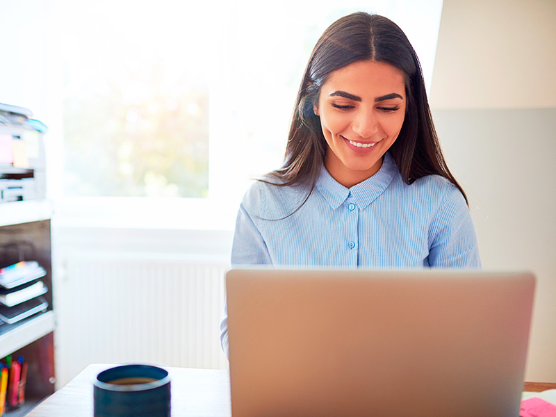 Na imagem, uma mulher está procurando no computador dicas de como escolher um lugar para fazer a cirurgia no nariz