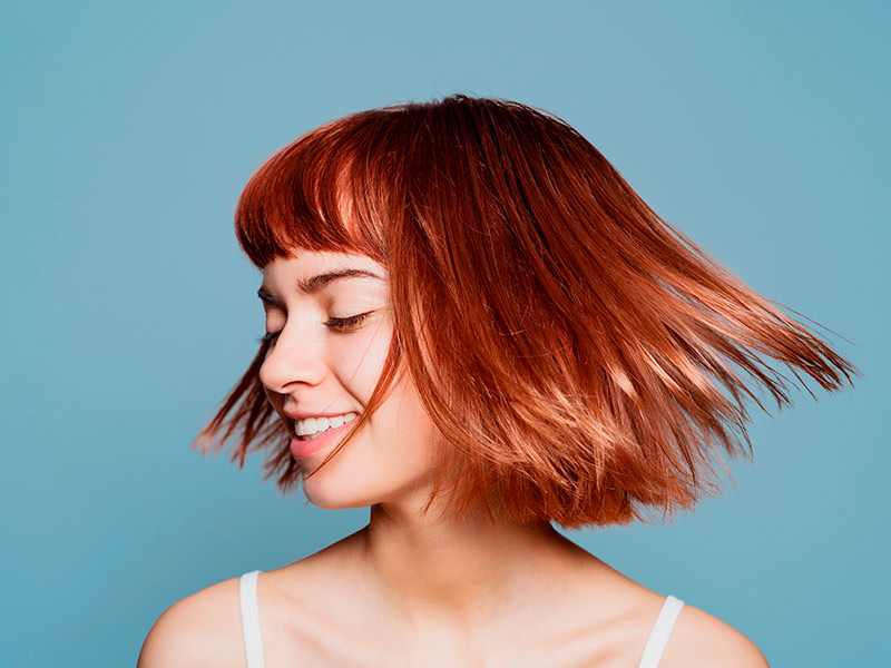 Mulher feliz com o seu penteado que cobre a orelha de abano