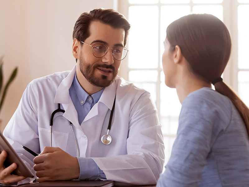 Médico conversando com paciente sobre o que está incluso na media de preço da mastopexia