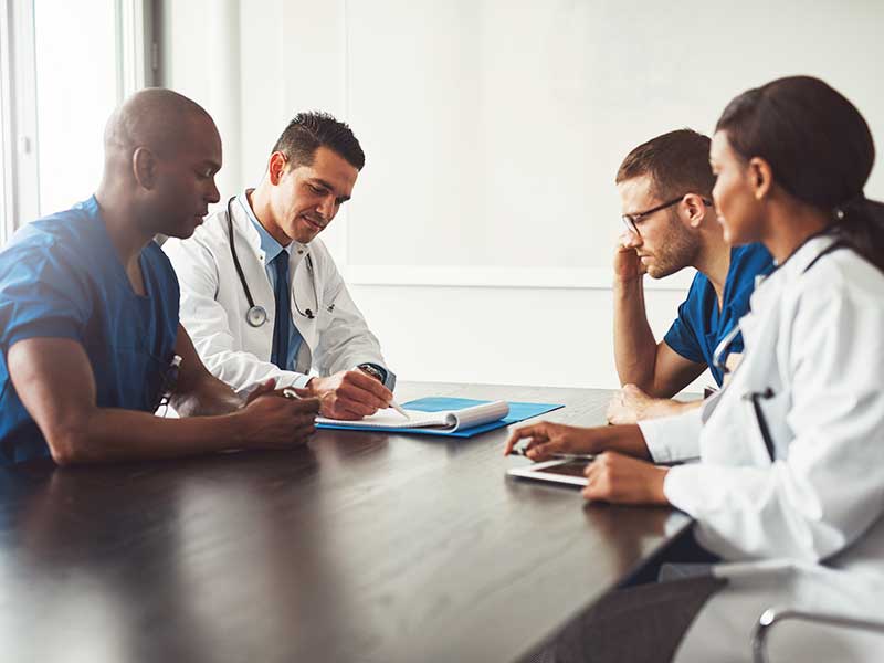 Como escolher o médico ideal para a minha cirurgia? Médicos cirurgiões conversando antes da cirurgia de prótese de silicone