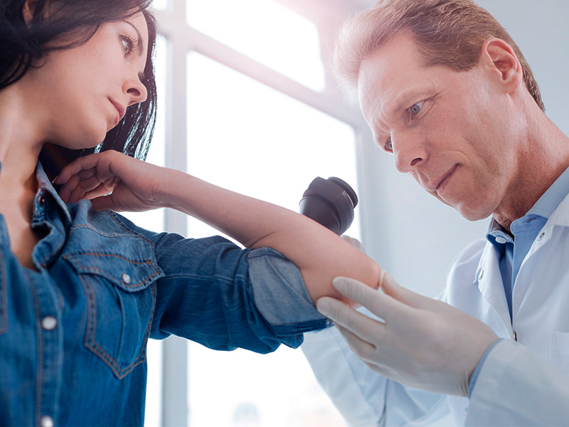 médico analisando se paciente tem cisto sebáceo ou lipoma no braço