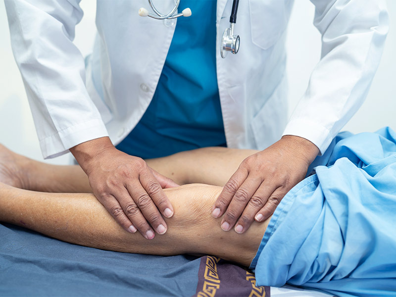 Médico avaliando o joelho de paciente no pré-operatório lifting de coxas