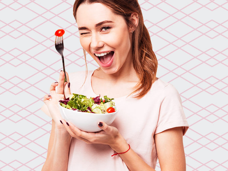 Dieta para chapar a barriga funciona? mulher fazendo dieta para chapar barriga, na imagem ela está feliz comendo salada