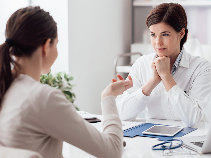 Mulher discutindo com a médica sobre os riscos da microabdominoplastia