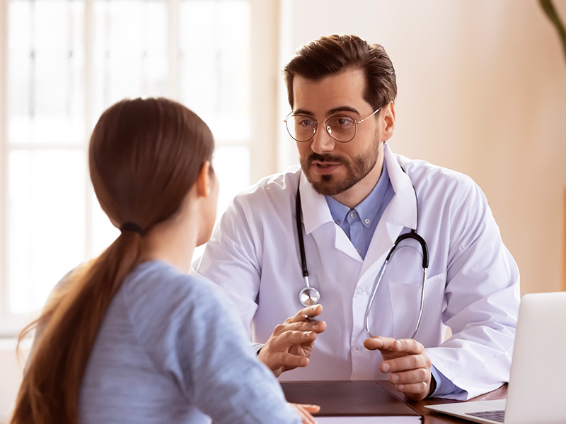 Consulta de pré-operatório da abdominoplastia mulher conversando com o médico sobre os cuidados para pré operatório abdominoplastia