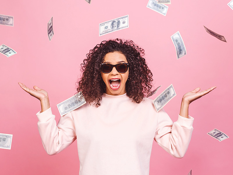 mulher em fundo rosa com dinheiros em volta feliz com preço do explante de silicone