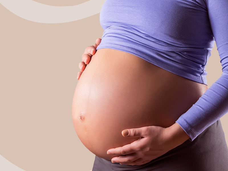 Grávida segurando a barriga, que descobriu que gestantes não devem fazer congelamento de gordura