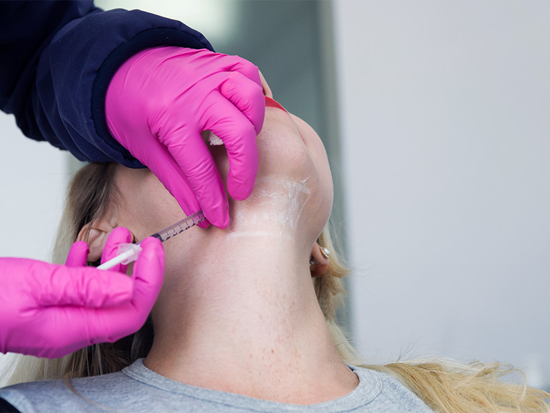 Imagem de uma mulher realizando uma lipo de papada enzimática com um profissional especializado