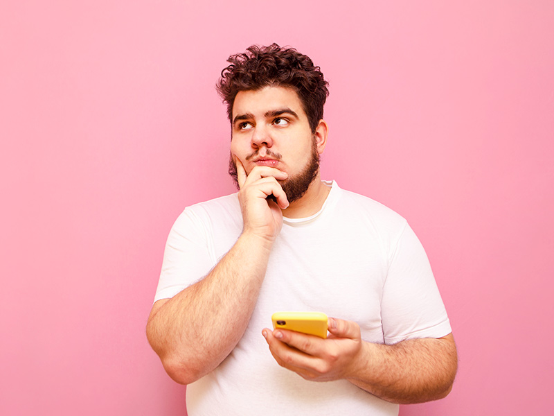 Homem pesquisando no celular como perder gordura abdominal 