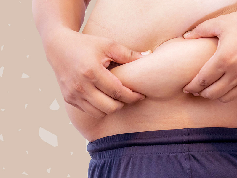 Homem apertando a barriga, querendo fazer lipoaspiração nos flancos masculina