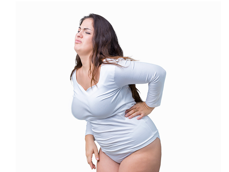 O que é hipertrofia mamária? Mulher inclinada para frente com dor na coluna causada pelas mamas grandes