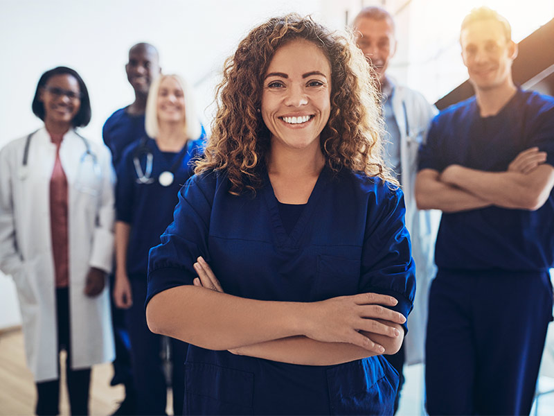 Equipe médica sorrindo, mostrando onde fazer a mamoplastia