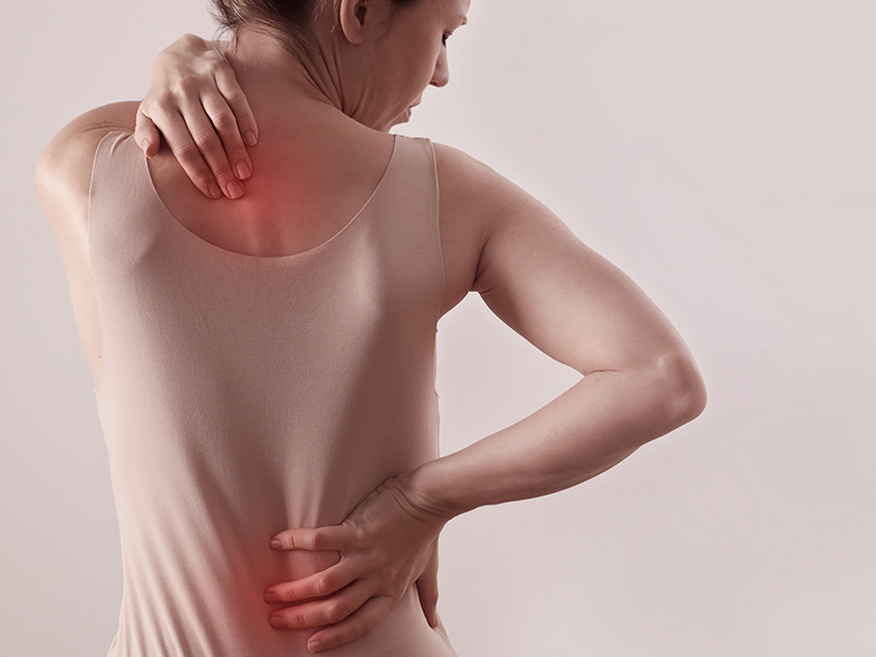 Mulher de costas com dor nas costas causada pela mama grande