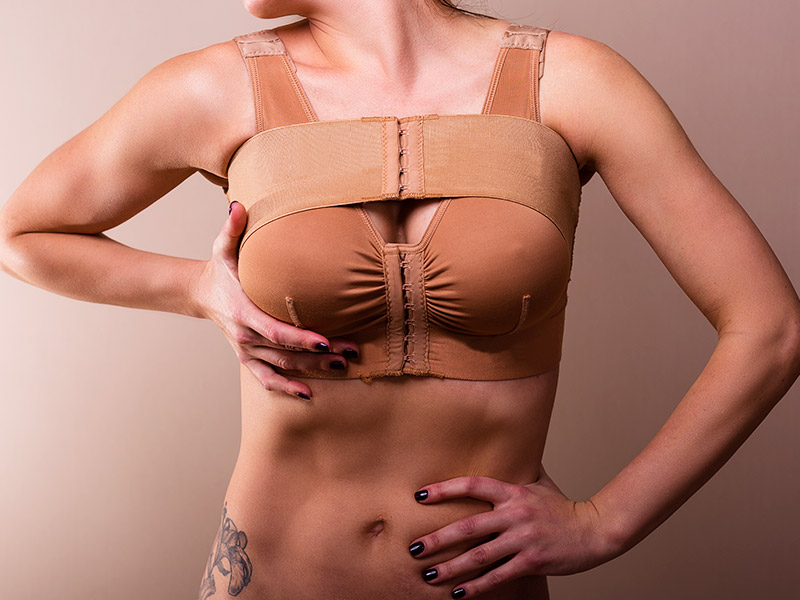 Mulher usando o sutiã pós-cirúrgico
