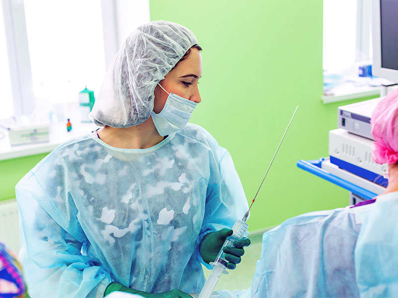 Imagem de uma médica segurando uma cânula de lipoaspiração tradicional, que é o tipo de lipo mais recomendado