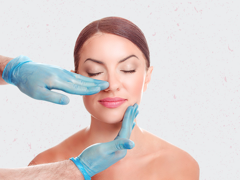 Quais os tipos de Rinoplastia? Cirurgião analisando o tipo de nariz da paciente