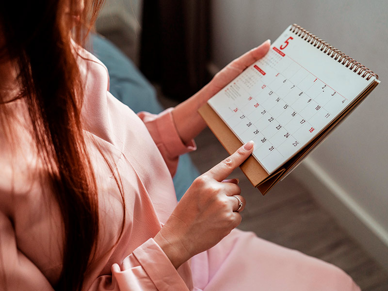 Mulher checando um calendário para ver o tempo de recuperação da rinoplastia