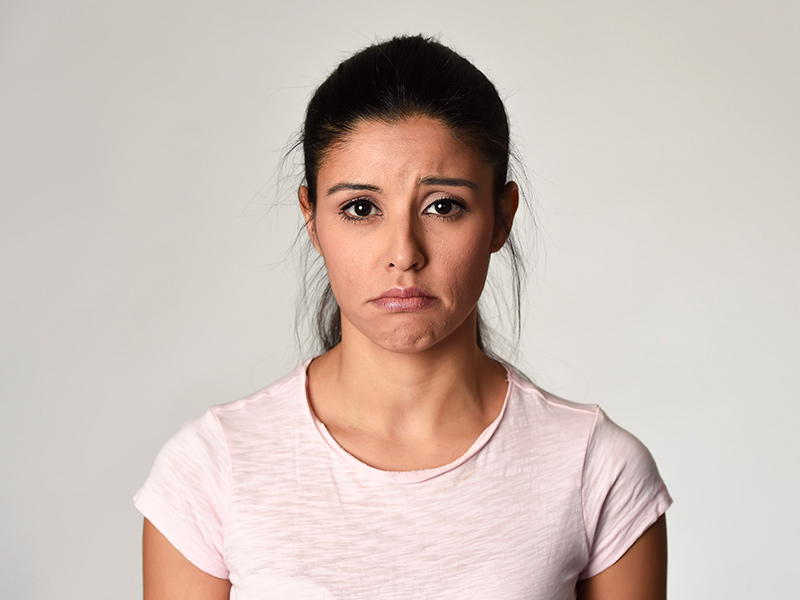O que é otoplastia fechada? Foto de uma mulher visivelmente triste por causa da técnica de otoplastia fechada
