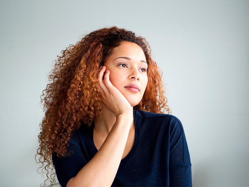 mulher pensando em fazer massagem modeladora ou drenagem linfática