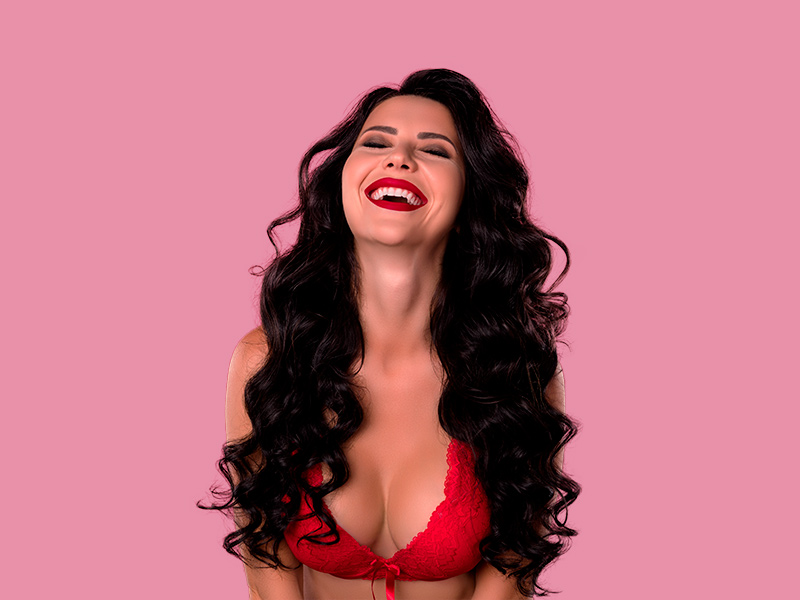 É possível colocar prótese de silicone pelo SUS? Mulher em um fundo rosa feliz por ter conseguido silicone pelo SUS