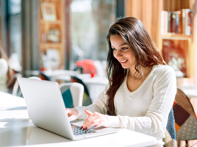 Imagem de uma mulher pesquisando no notebook como comprar toxina botulínica