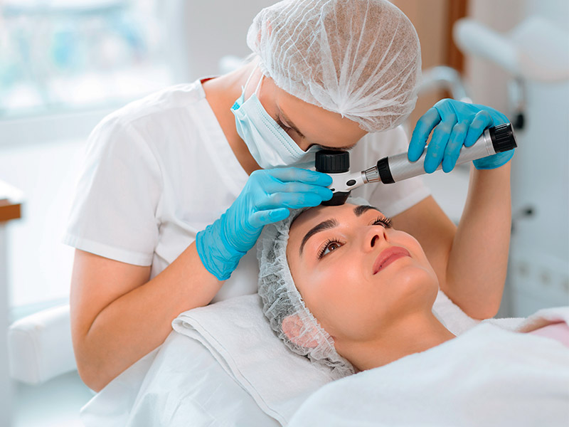 Imagem de uma profissional avaliando a pele da paciente antes de aplicar botox