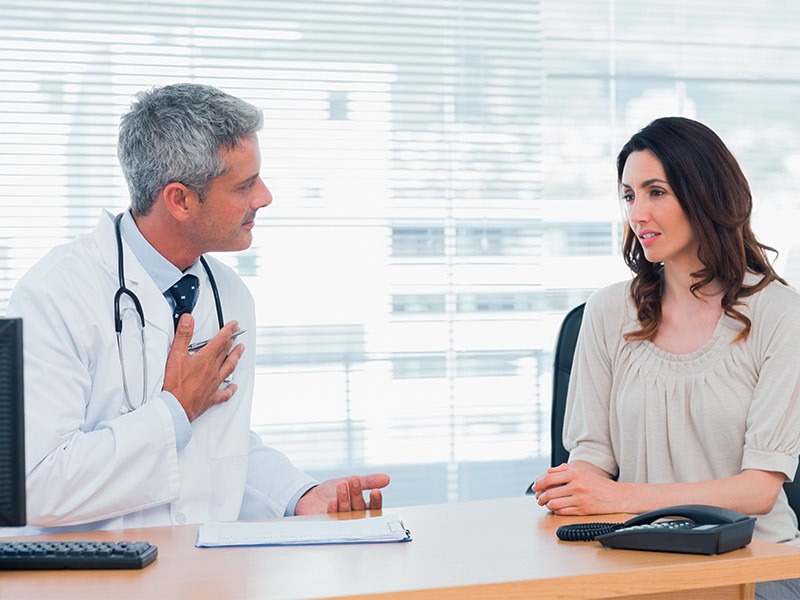 Como é feito o implante de prótese de silicone na panturrilha? médico conversando com paciente sobre a cirurgia de panturrilha