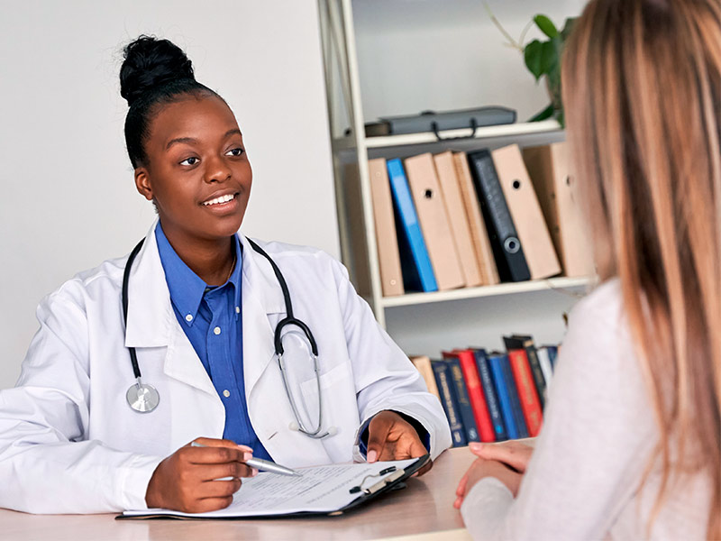 Imagem de uma médica conversando com a paciente sobre todas as recomendações para o período de recuperação da torsoplastia