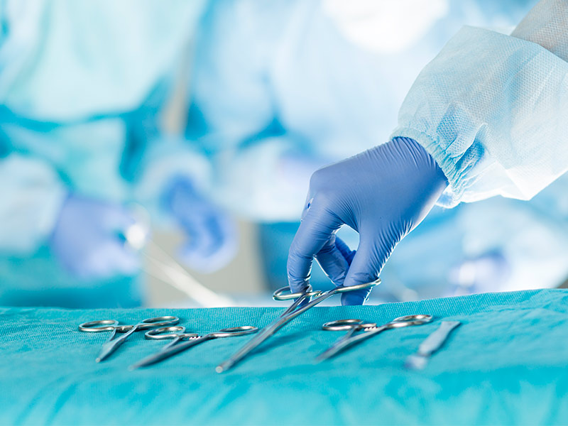 Imagem de um médico segurando instrumentos cirúrgicos 