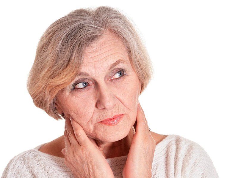 Imagem de uma mulher idosa com expressão de dúvida, se questionando o que poderia ter feito para prevenir as marcas de expressão no rosto e pescoço