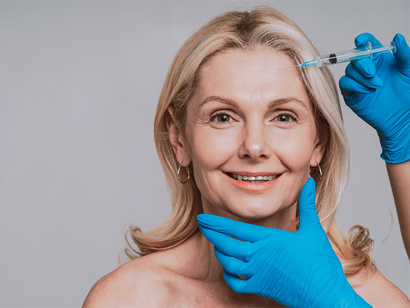Imagem de uma mulher realizando a aplicação de botox para eliminar as marcas de expressão no rosto