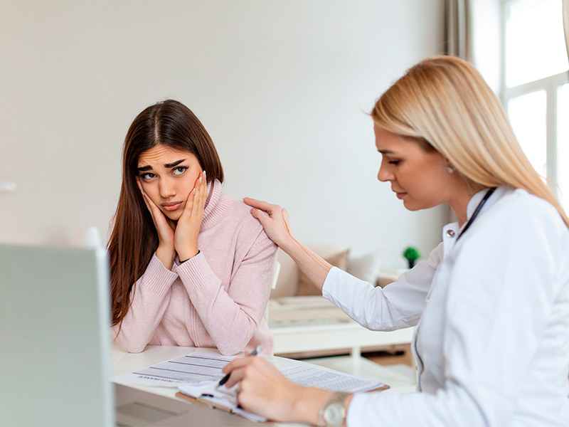 Médica conversando com paciente preocupada sobre pus nos pontos da cirurgia e deiscência