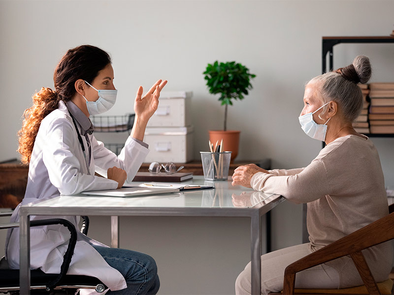 Imagem de uma médica conversando com sua paciente sobre as recomendações de pré-operatório do mini lifting