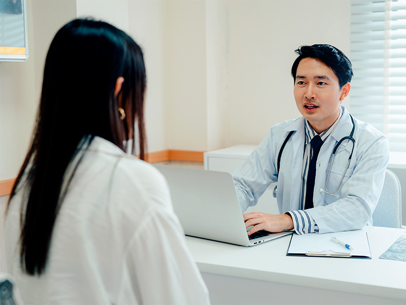O que interfere no resultado da prótese de silicone na mama? mulher em clinica conversando com médico sobre implante mamário