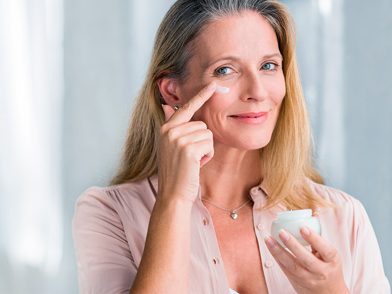 Mulher passando creme no rosto para eliminar bigode chinês naturalmente