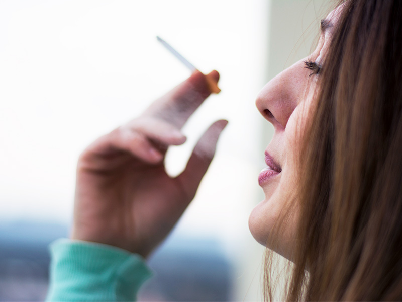 Mulher de lado fumando um cigarro