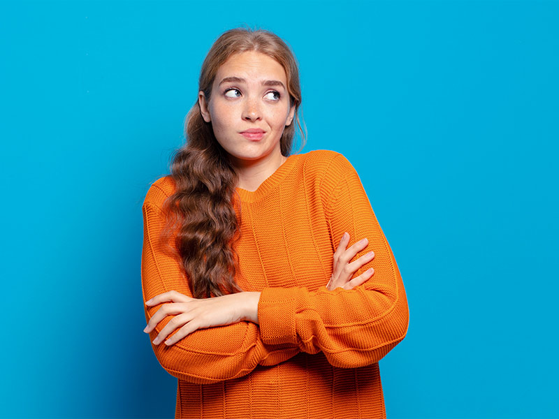 Imagem com fundo azul e uma mulher de braços cruzados, com expressão de dúvida, e se perguntando para que serve hidrogel