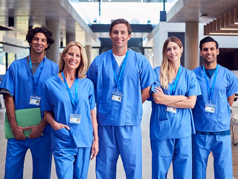 Equipe de enfermeiros sorrindo em corredor