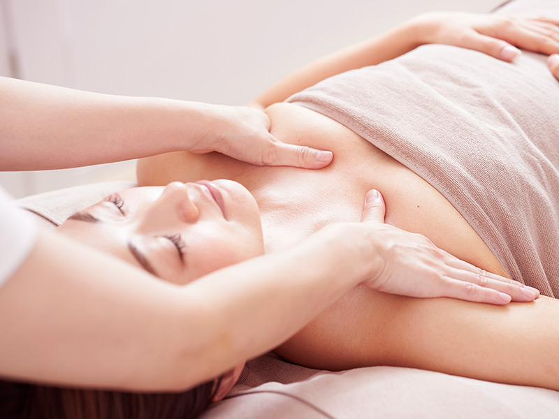 Mulher recebendo massagem para levantar as mamas