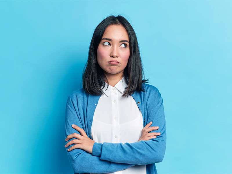 Imagem com fundo azul gradiente e uma mulher no centro, com expressão facial de decepção, pois fez a aplicação de bioestimulador de colágeno e não gostou.